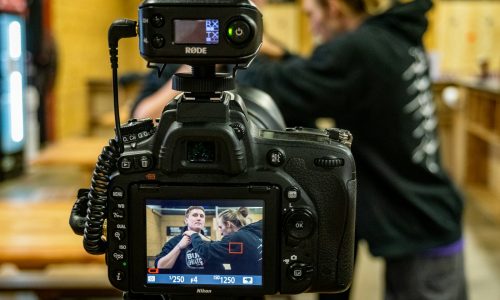 black DSLR camera beside two person